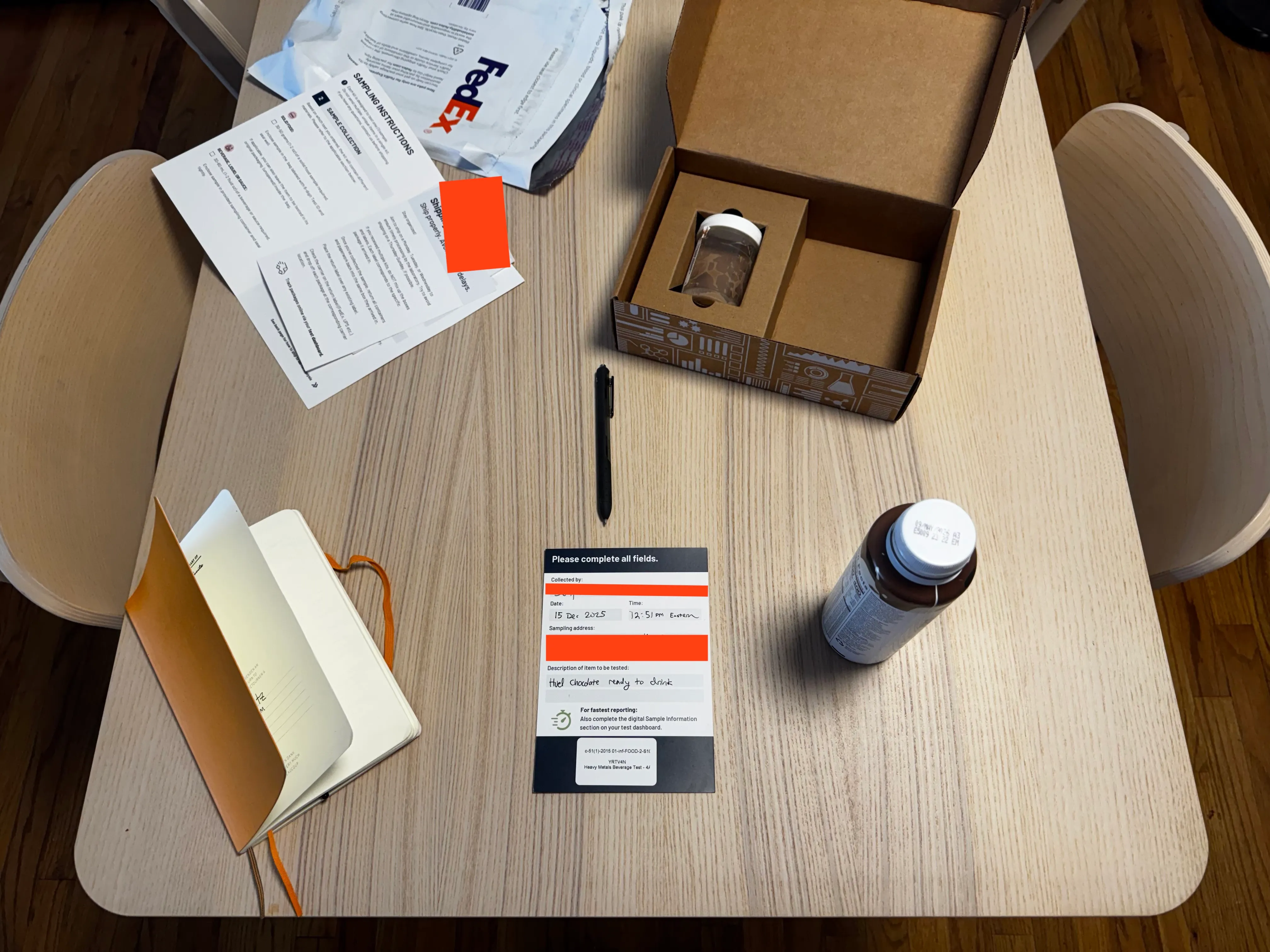 On a kitchen table, the SimpleLab collection kit and a bottle of Huel